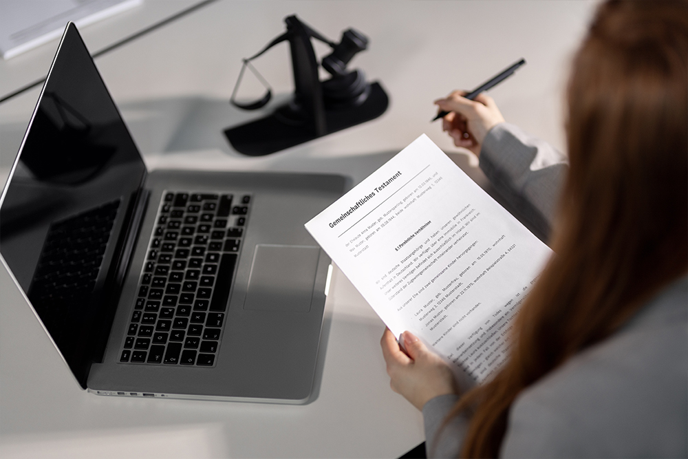 Eine Frau hält ein Dokument in den Händen mit der Überschrift "Gemeinschaftliches Testament".